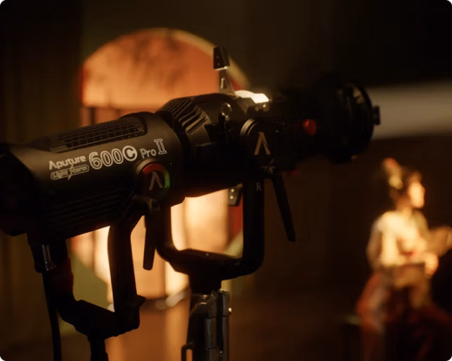 Світло Aputure LS 600c Pro 600W RGBWW Point Source LED (AP30126A21) 9 LS 600c Pro II з модифікатором на знімальному майданчику освітлює модель у теплих тонах